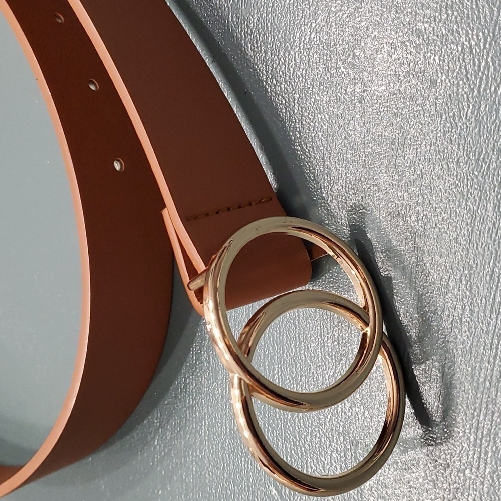 Tan leather belt, rose gold color buckle.. No name or size.
